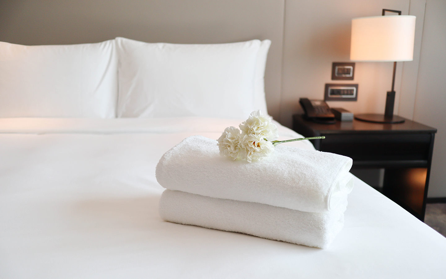 iStock_1303630250_hotel_bed_flowers_1440x900.jpg