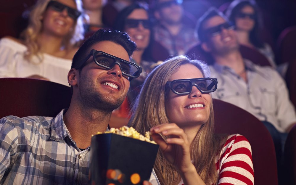 People watching a movie and eating popcorn