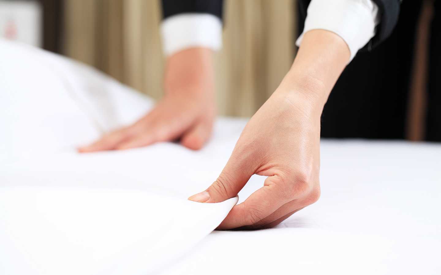 iStock_181130453_hotel_bed_hands_1440x900.jpg